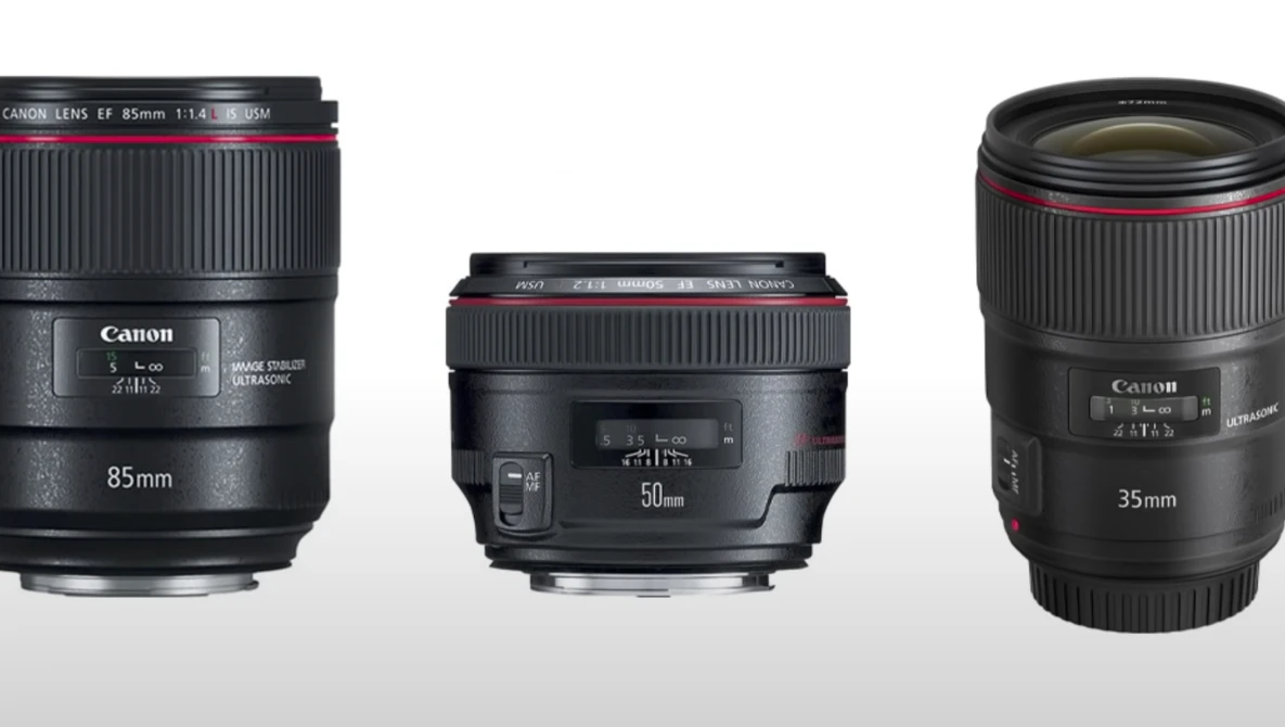 Three Canon prime lenses: 85mm f/1.4, 50mm f/1.8, and 35mm f/1.4 arranged side by side against a gray background.