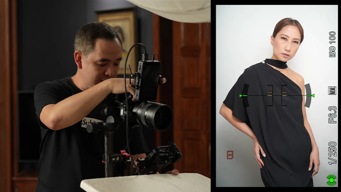 Photographer adjusting a camera mounted on a studio rig while monitoring a portrait subject on a display screen.