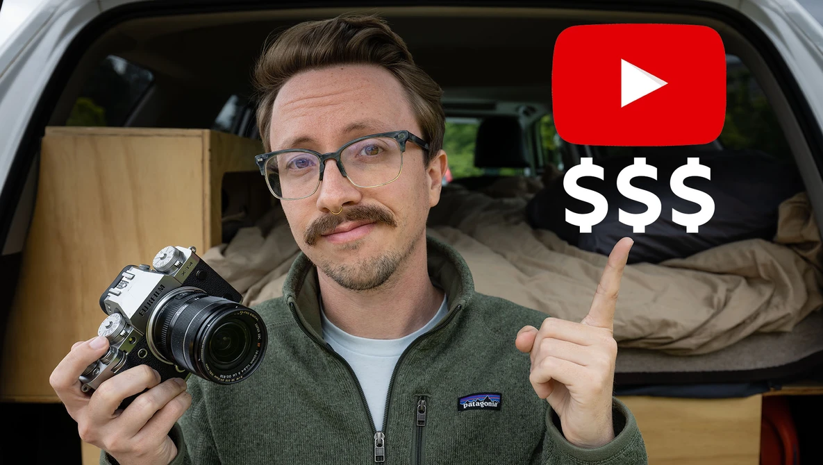 Man holding vintage film camera inside a van, pointing at YouTube and dollar sign graphics overlay.