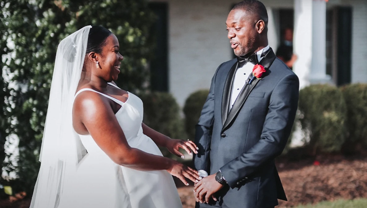 Bride and groom exchange rings during outdoor wedding ceremony.