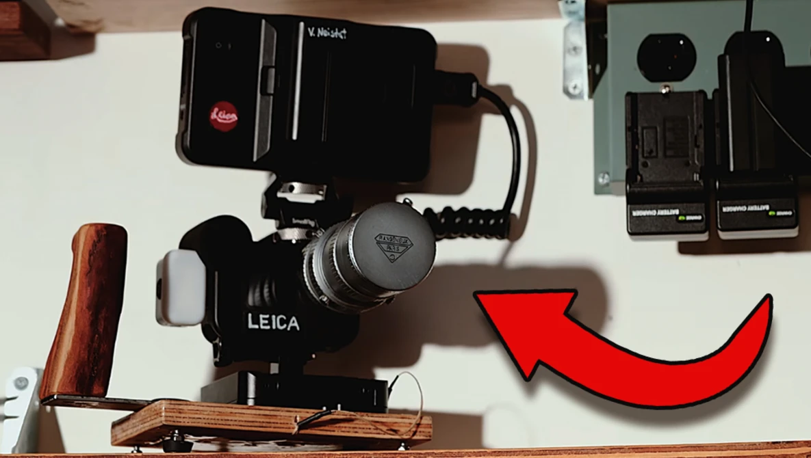 Leica rangefinder camera mounted on a wooden baseplate with a video light and external recorder setup.