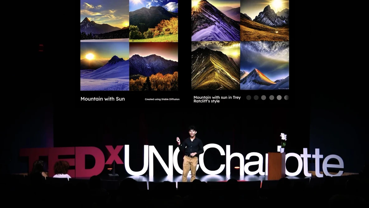 TEDxUNC Charlotte stage setup with mountain landscape photographs displayed above.