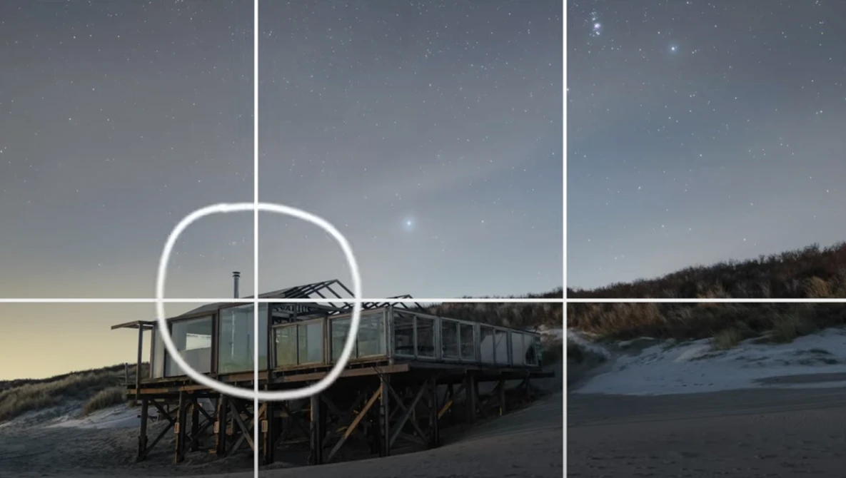 Beach structure with grid overlay and circular framing guide positioned over wooden platform building.