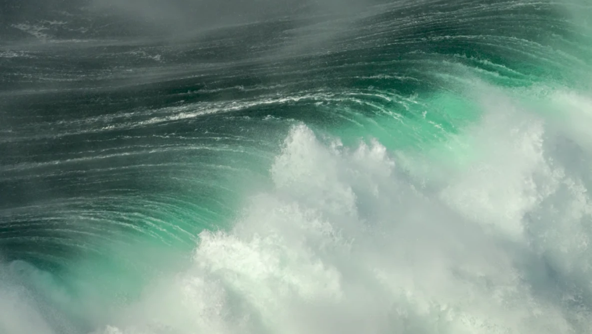 Dramatic ocean wave with turquoise water and white foam captured mid-break.
