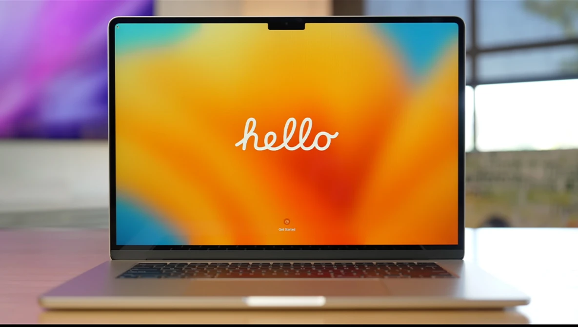 Laptop displaying a colorful gradient wallpaper with the word "hello" in white script text.