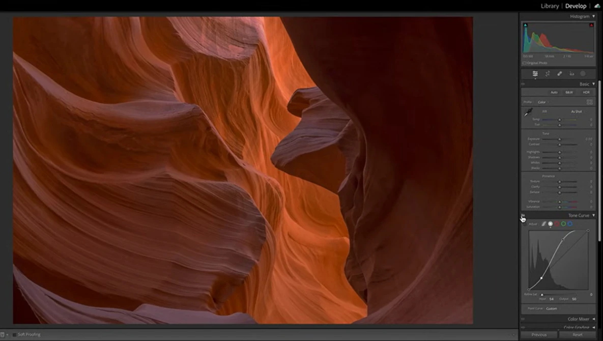 Slot canyon with smooth, flowing sandstone walls in warm orange and deep red tones under natural light.