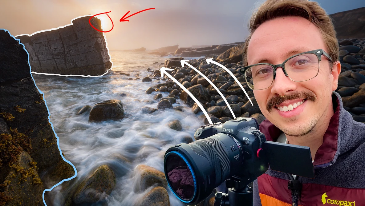 Photographer holding mirrorless camera at rocky coastal location during golden hour with waves and stone formations.