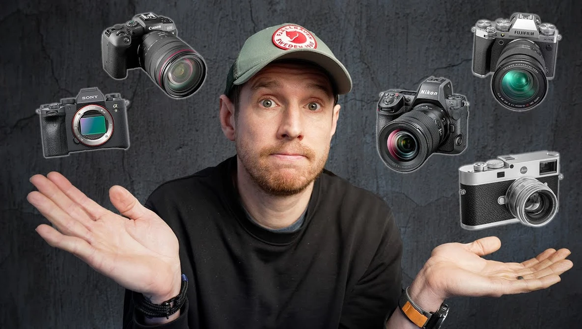 Photographer wearing cap with hands gesturing uncertainty, surrounded by six different camera models floating around him.