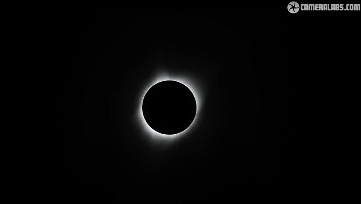 Total solar eclipse with the moon blocking the sun and corona visible as a bright halo against a black sky.