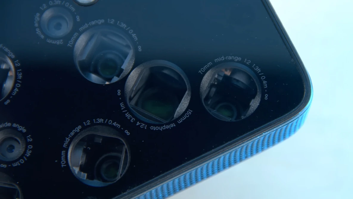 Close-up view of a smartphone's multi-lens camera module with four lenses and technical specifications printed on the dark back panel.