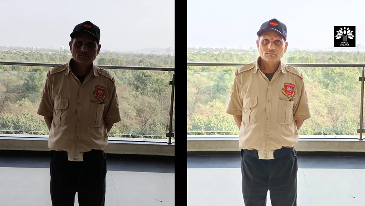Two men in tan uniforms with red patches standing indoors with forested landscape visible through windows behind them.