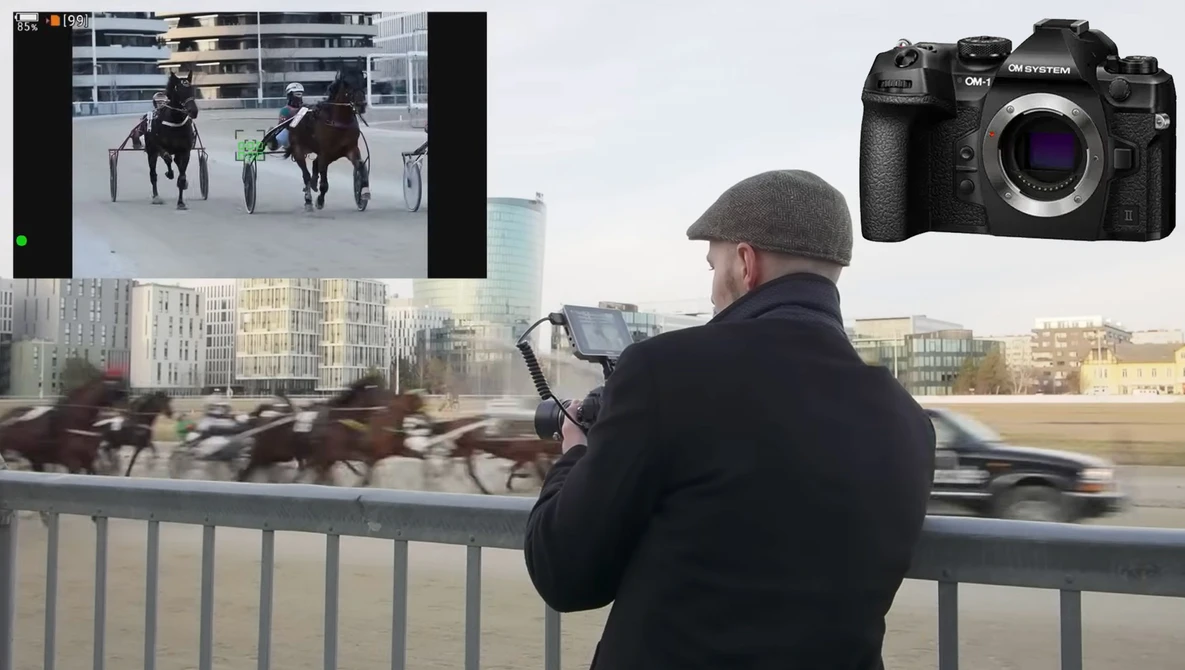 Photographer capturing harness racing from a bridge railing with a mirrorless camera.