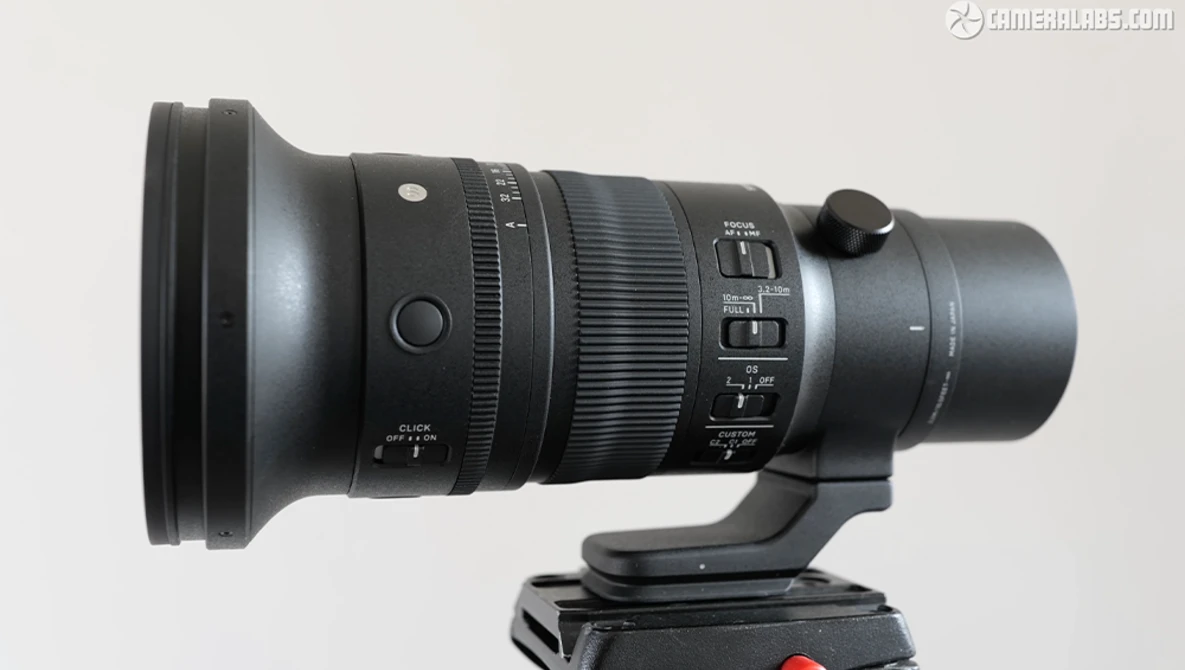 Telephoto lens with focus ring and aperture controls mounted on tripod head.