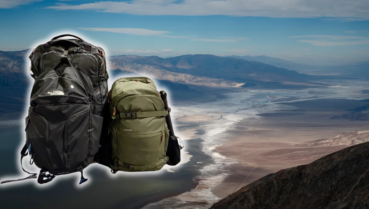 Two hiking backpacks positioned on a mountain overlook with expansive aerial landscape below.