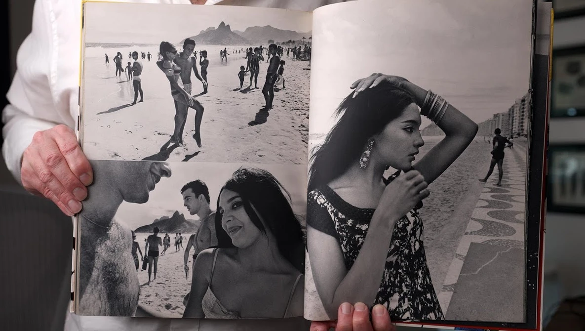 Open photography book displaying black and white beach portraits and candid shots across two pages.