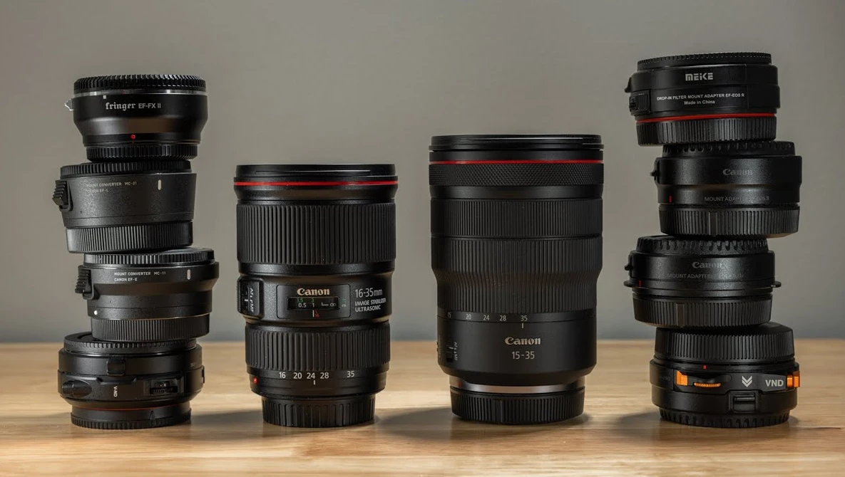 Four stacked camera lenses of varying focal lengths arranged in ascending height order against a neutral background.