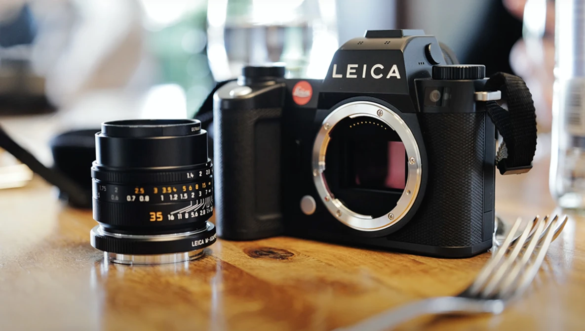 Leica SL2 camera body with 35mm lens on wooden surface.