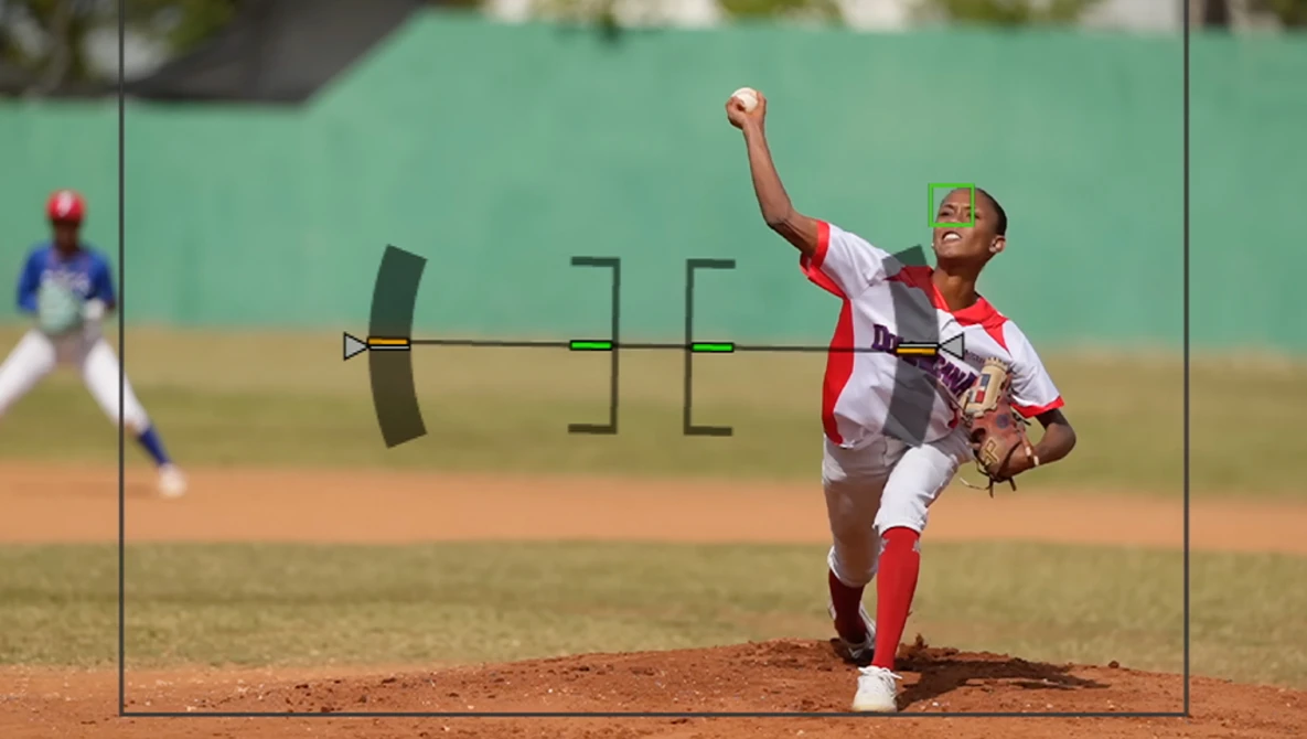 Young baseball pitcher mid-delivery wearing red and white uniform on dirt mound.