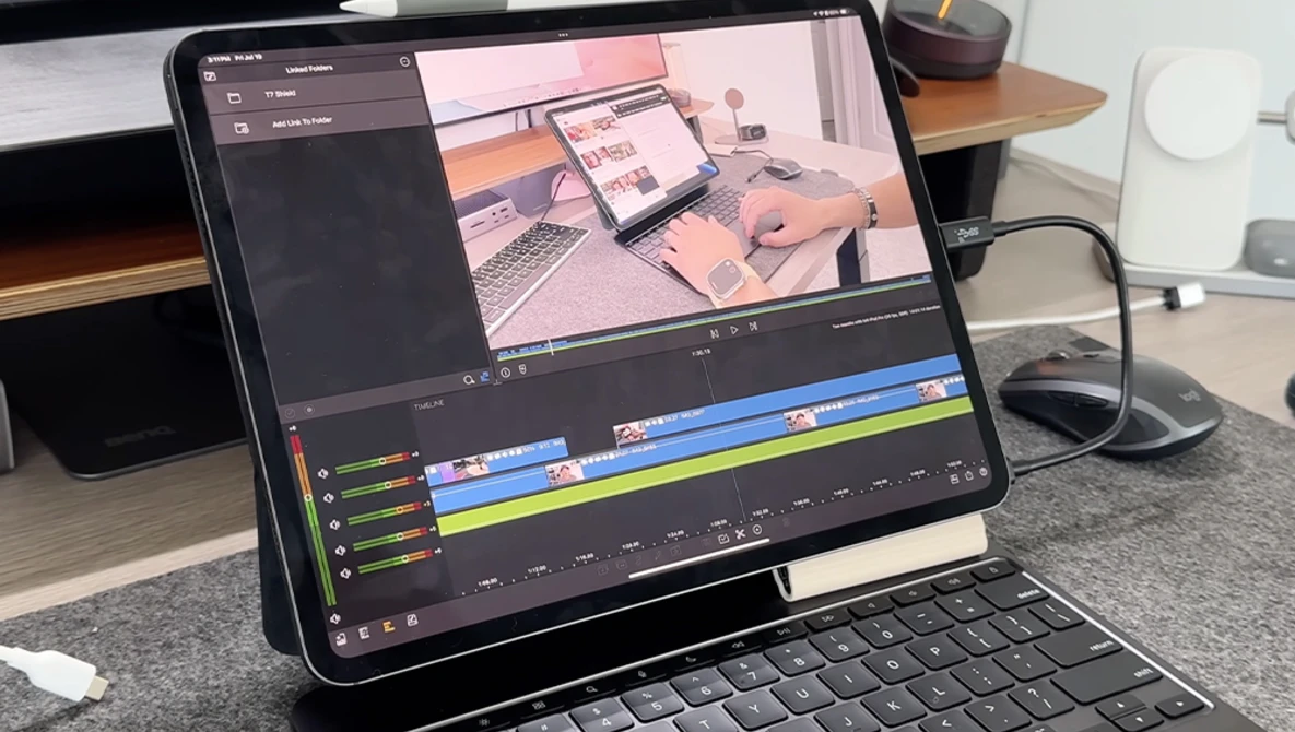 Screenshot of video editing software with timeline showing color-coded clips and preview of workspace setup on tablet screen.