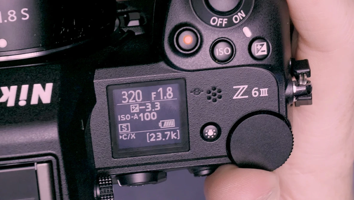 Close-up of a Nikon Z6 III camera's rear LCD screen and control buttons displaying shooting settings.