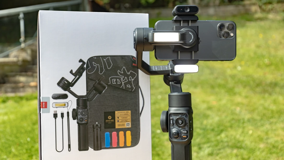 Smartphone gimbal with mounted phone and accessory kit displayed on white product card.
