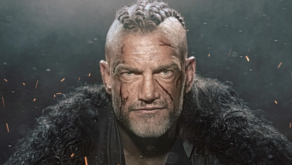 Portrait of a man with styled gray hair and facial scars against a dark background with orange light effects.