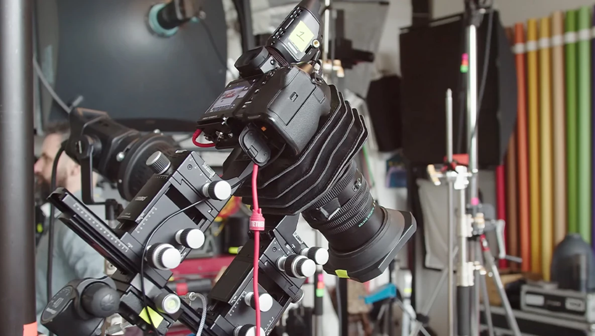 Professional camera rig with multiple lenses and wireless monitoring equipment mounted on tripod in studio setting.