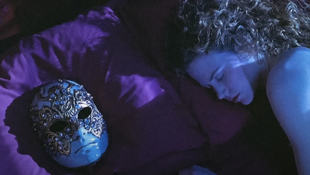 Ornate spherical object with intricate metalwork details held in hands against purple and blue ambient lighting.