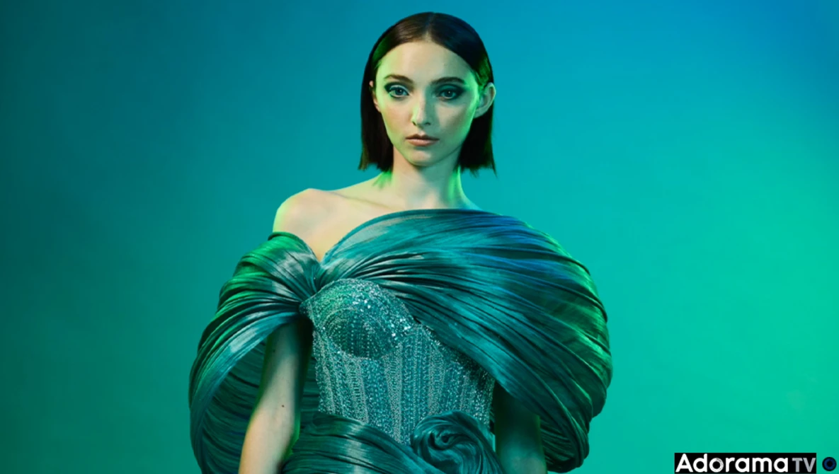 Woman in turquoise off-shoulder gown against monochromatic teal background.