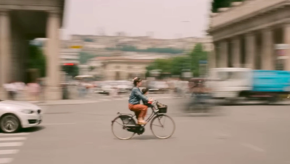 Cyclist riding through urban plaza with motion blur effect surrounding the figure.