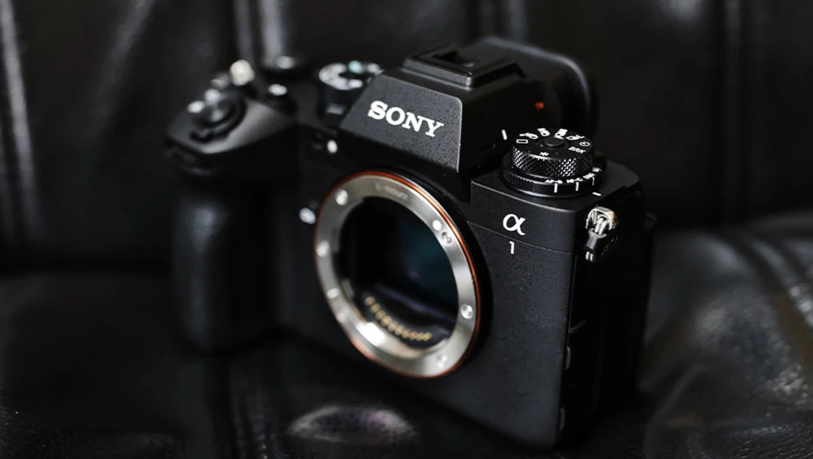 Sony α mirrorless camera body with exposed sensor and mount, displayed against dark fabric backdrop.