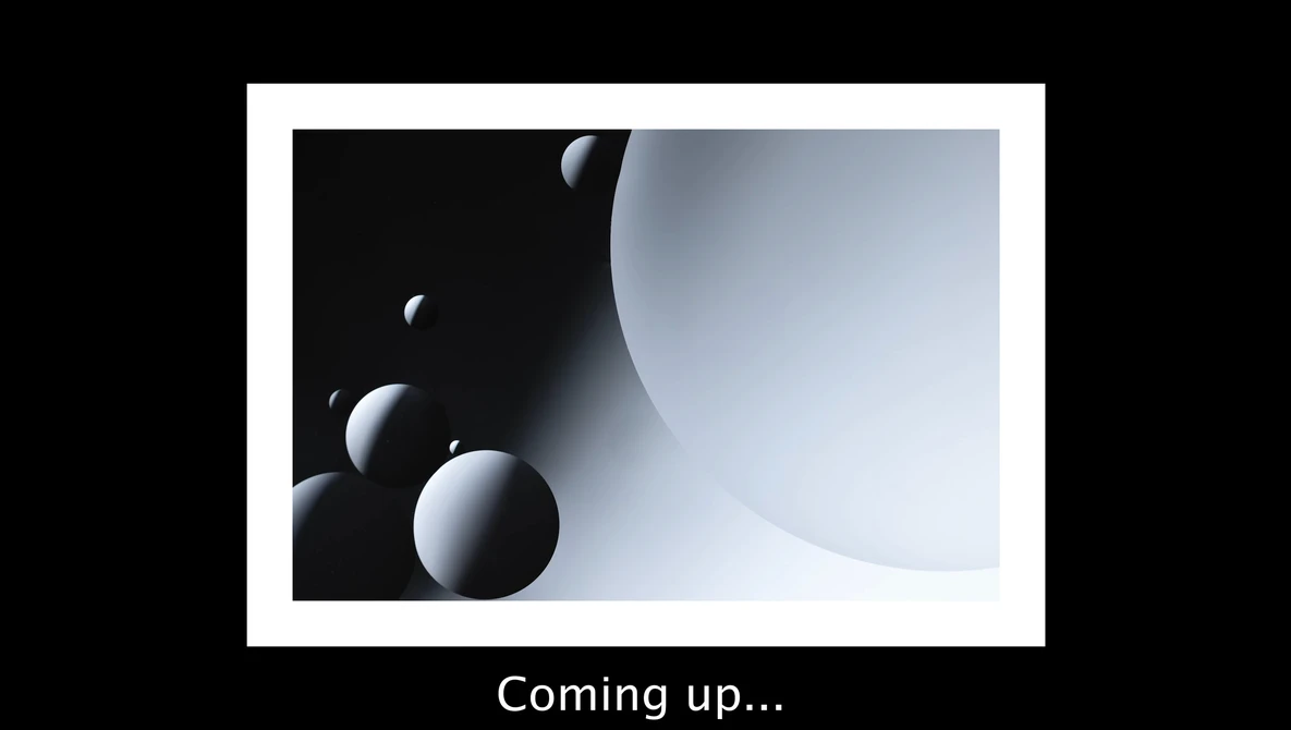 3D render of white spheres in graduated sizes arranged against dark and light curved surfaces.