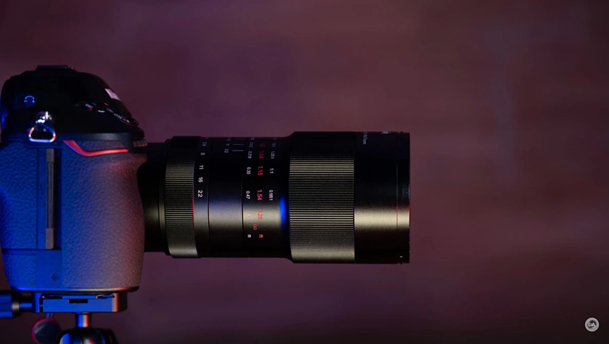 Telephoto lens mounted on blue camera body against purple background.