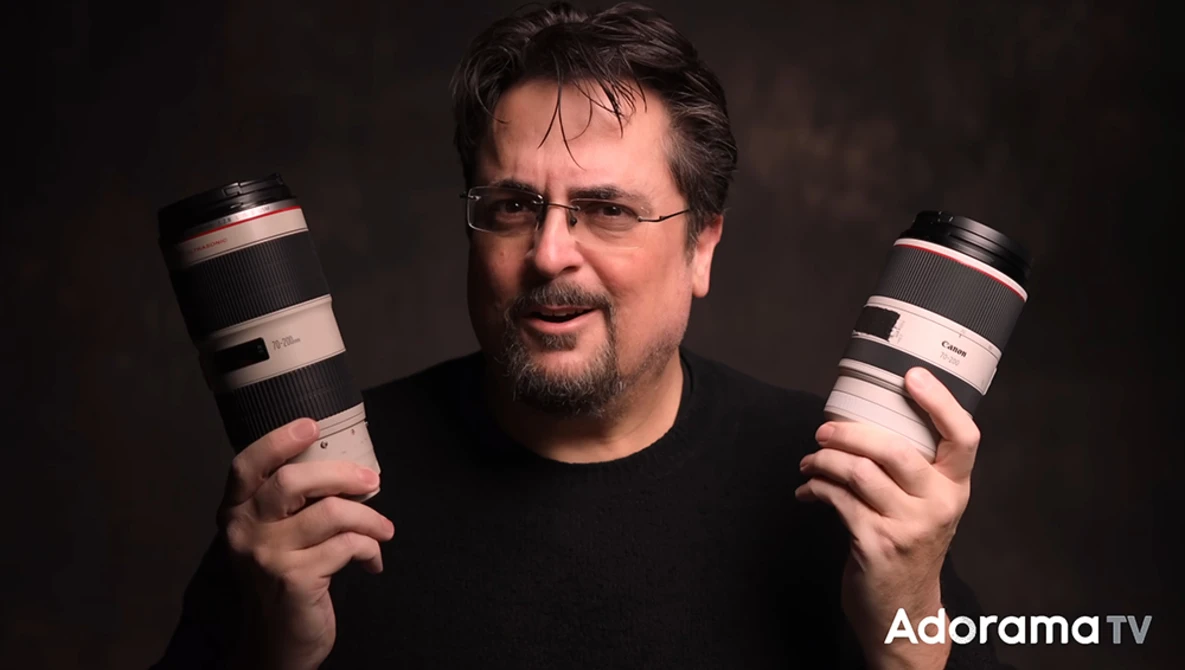 Photographer holding two telephoto lenses against a dark background.