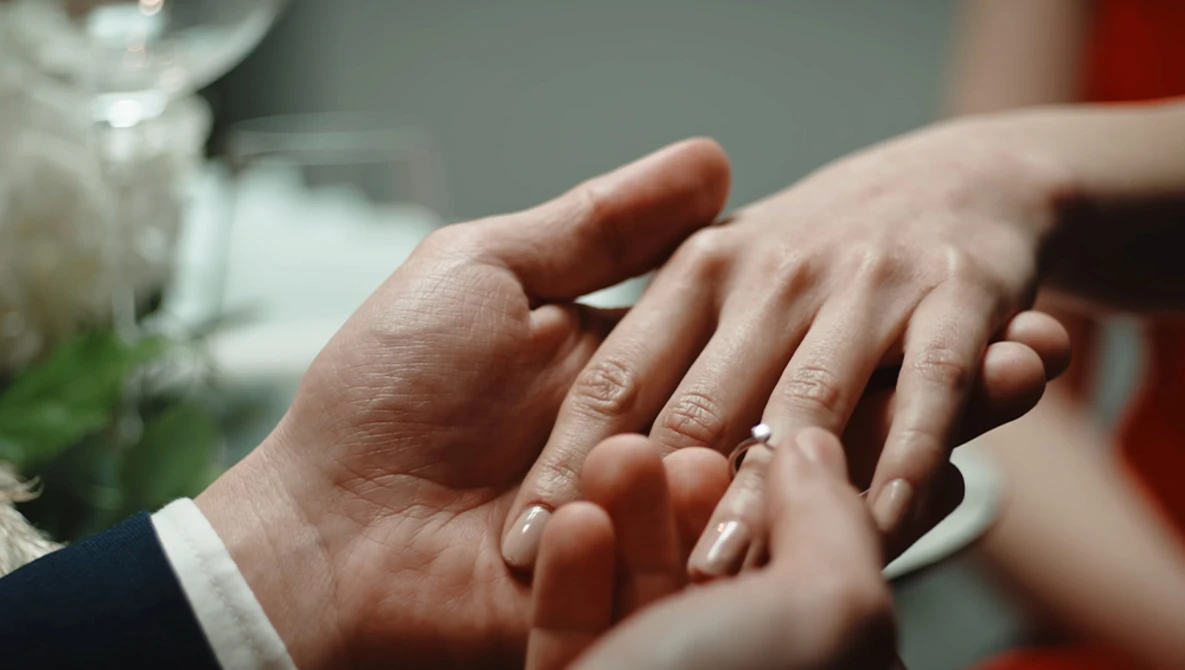 Newlyweds' hands displaying wedding rings in close-up detail.