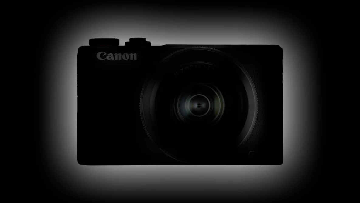 Canon compact digital camera silhouetted against a dark background with rim lighting.