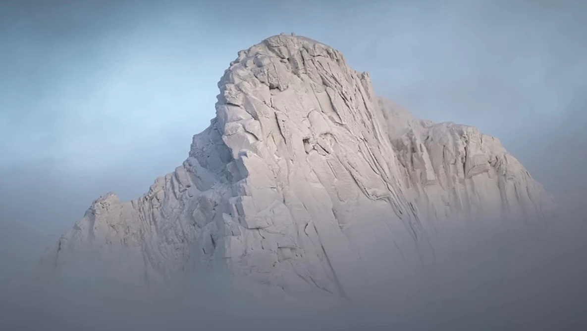 Snow-covered rocky peak emerging from thick fog and mist under overcast sky.