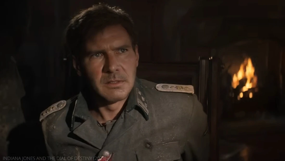 Man in military uniform seated before a fireplace with warm amber lighting.