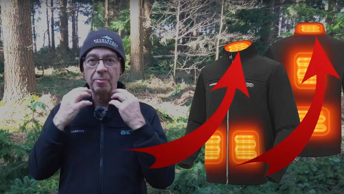 Man in dark jacket and beanie standing outdoors with forest background, demonstrating heated jacket with glowing thermal patterns illustrated with red arrows.