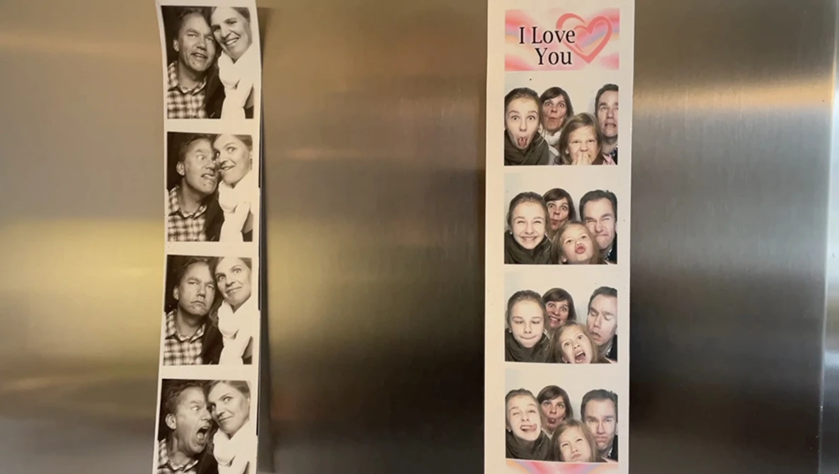 Two photo booth strips displayed on a refrigerator, showing couples in candid moments.