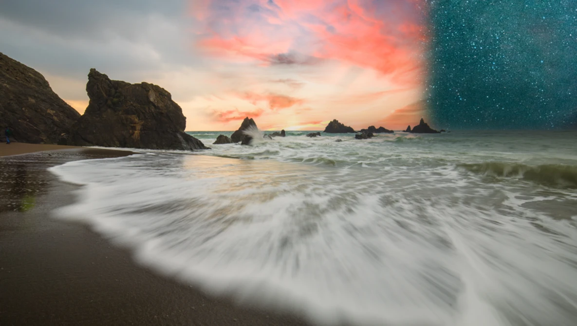 Long-exposure seascape with smooth waves rolling onto a sandy beach at sunset, rocky outcrops visible in the background.