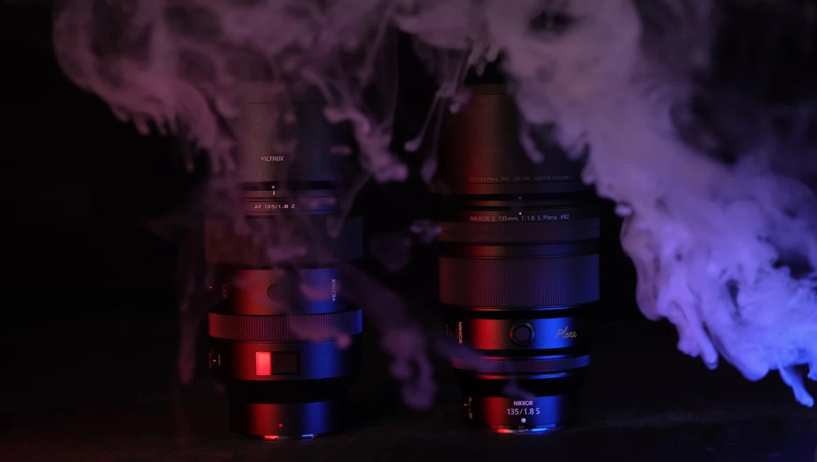 Two camera lenses with red and blue LED lighting creating atmospheric smoke effects against a dark background.
