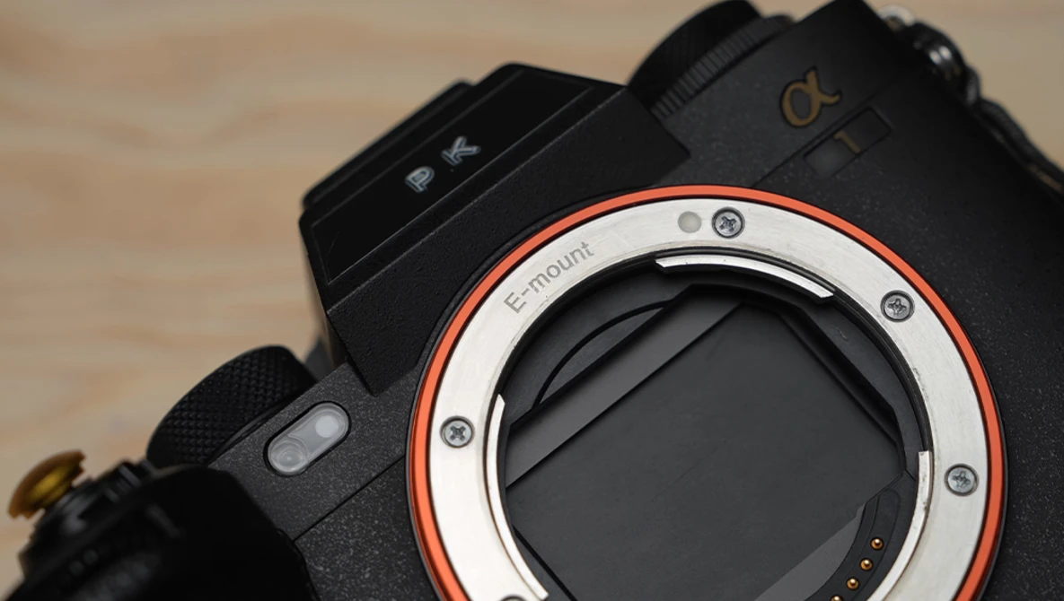 Sony Alpha mirrorless camera body with red accent ring around lens mount, viewed from front.