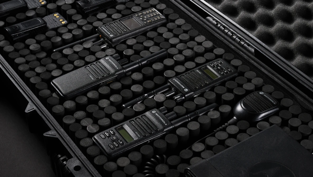 Multiple portable radios arranged in a protective foam-lined carrying case.