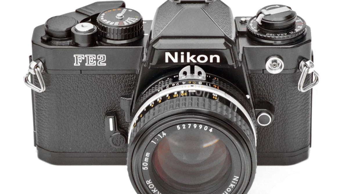 Nikon FE2 film camera with standard 50mm lens mounted, shot from front against white background.