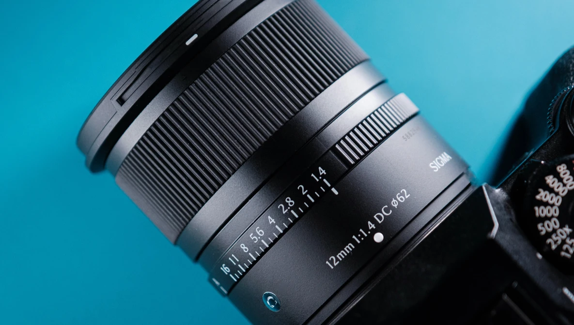 Telephoto zoom lens with focal length markings visible against a bright blue background.