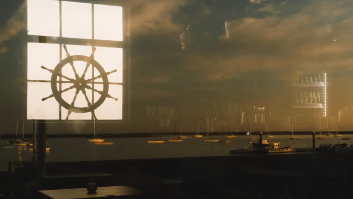 Ship's wheel silhouetted against a bright window in warm, atmospheric interior lighting.