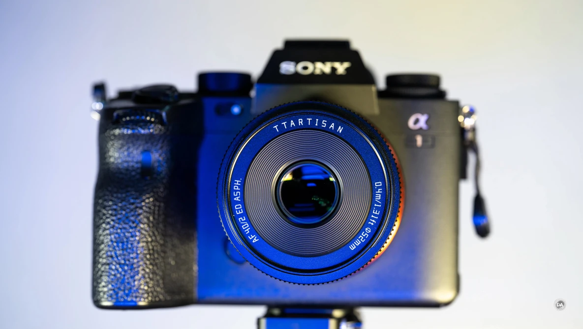 Three vintage and modern cameras arranged in a row against a light background, with a blue Startisan camera in sharp focus in the foreground.