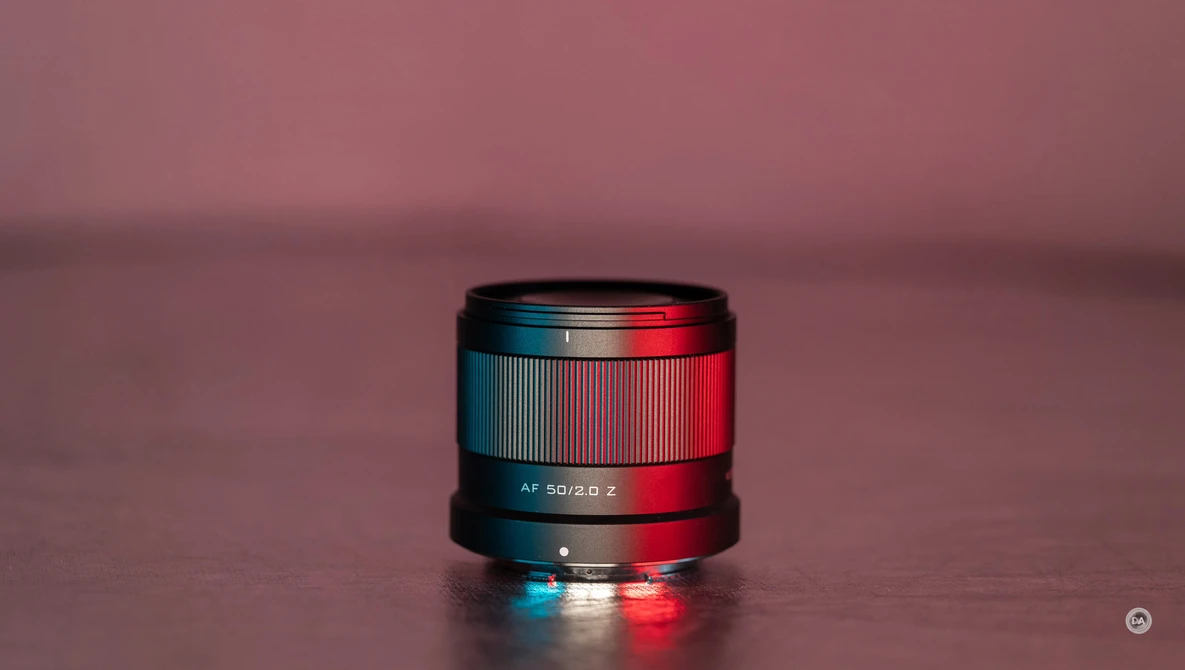Camera lens with blue and red gel lighting against a pink background.