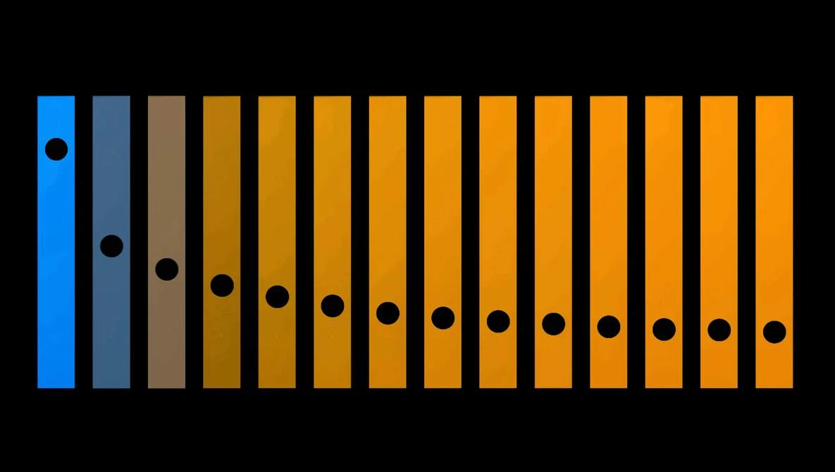 Illustration of 14 vertical bars with holes representing an aperture scale or f-stop sequence.